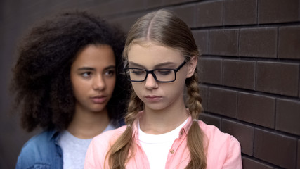 Cruel black student bullying caucasian schoolgirl eyeglasses, emotional pressure