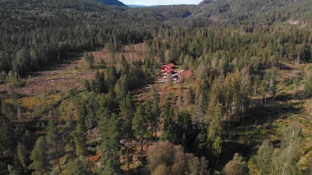 Aerial view over Heisetra cabins with a beautiful lake and lots of pine trees and forest surrounding the cabins, in Kodal, Norway