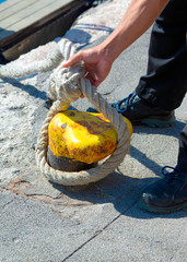 Sailor ties a boat to a harbor bollard