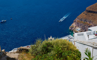 Beautiful view of white typical village and Aegean Sea i. View of blue domed churches -famous tourist attraction in Greece.