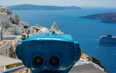 Beautiful view of white typical village and Aegean Sea i. View of blue domed churches -famous tourist attraction in Greece.