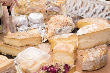 Different sorts of cheese wheels at a market