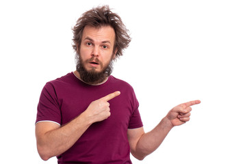 Portrait of surprised bearded man pointing fingers to copy space. Look over there! Crazy male pointing away and looking at camera. Amazed caucasian man with funny haircut.