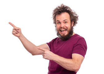 Portrait of happy bearded man pointing fingers to copy space. Look over there! Crazy male pointing away and looking at camera. Smiling and laughing caucasian man with funny haircut.