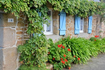 Fototapeta na wymiar Fenêtres aux volets bleus d'une maison bretonne typique. France