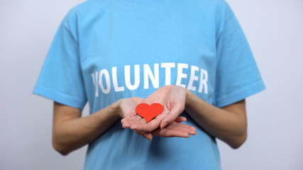 Red heart sign in volunteer palms, health care, transplantation center, medicine