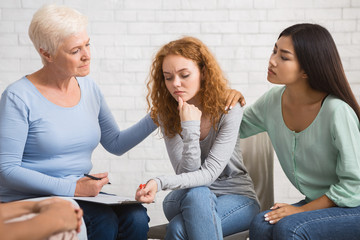 Diverse Women Supporting Depressed Girl On Group Therapy Session Indoor