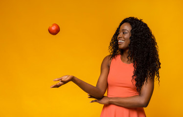 Female fitness model playing with red apple