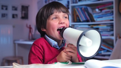 a lonely boy sits at a table, shouts in a megaphone, protests