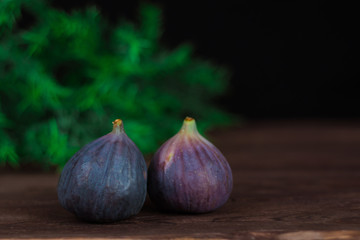Fototapeta premium Fig fruits. Still life of figs on a dark wooden table.