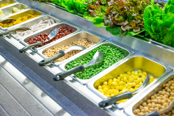 Freshly cut vegetables are lined up in a tray for sale as a vegetable salad in the supermarket.