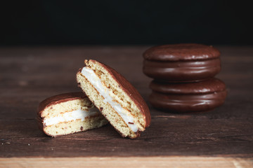 Chocolate chip cookies on a dark wooden table. Cookies cut in half. Background image. Tasty breakfast.