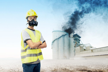 Asian engineer man using a protective mask to protect him against air pollution from the industrial factory
