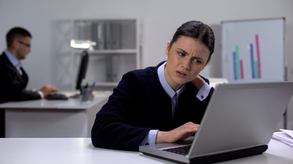 Female manager working on laptop in office feeling neck pain, sedentary life