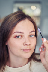 Close up of beautiful face of young woman getting make-up