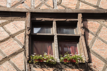Fototapeta na wymiar Vieille fenêtre fleurie dans une rue de Chinon