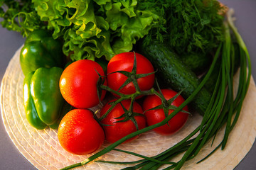 pepper, tomatoes, cucumbers, fresh herbs, onions. Fresh vegetables lie on the table.