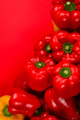 Fresh red, yelow, green bell pepper on a red background.