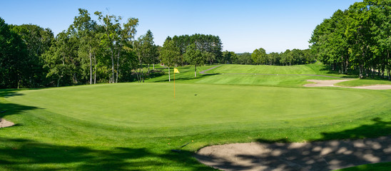 Panorama View of Golf Course with beautiful putting green. Golf course with a rich green turf beautiful scenery.