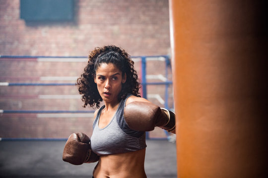 Female boxer punching a punch bag