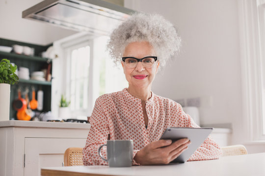 Portrait of senior adult female looking at digital tablet at home