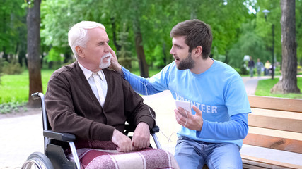 Volunteer and handicapped elderly man listening motivate podcast together