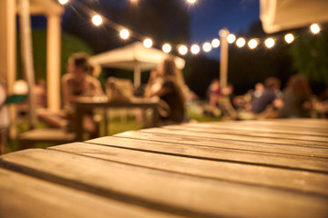 view of a wooden table on the terrace of a bar - obrazy, fototapety, plakaty