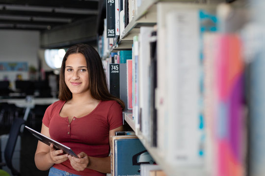 Portrait of hispanic high school student in library