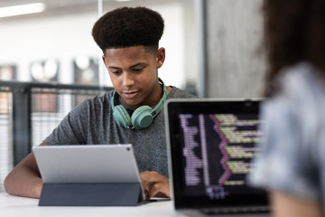 African American male student coding in class