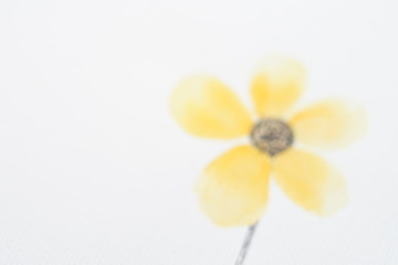 background unfocused yellow painted flower on white paper with copy space.