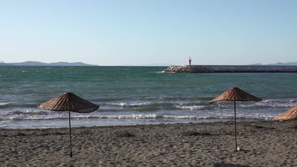 Silhouetted beach umbrella in front of a quiet empty ocean horizon.