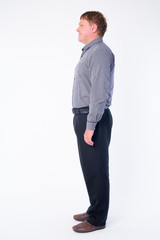 Full body shot profile view of happy overweight businessman smiling