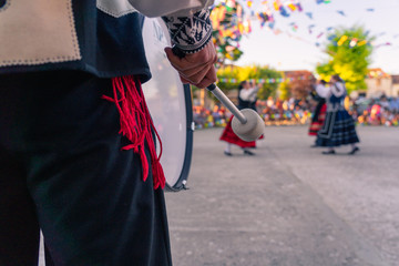 Detail of bass drum, typical instrument. Person who dances in the background, traditional dance of Segovia.