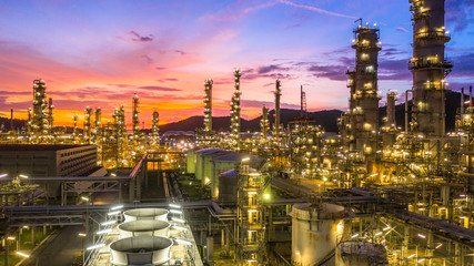 Oil​ refinery​ with oil storage tank and petrochemical​ plant industrial background at twilight, Aerial view oil and gas refinery at twilight. - obrazy, fototapety, plakaty