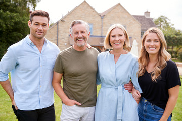 Portrait Of Family With Senior Parents And Adult Offspring Walking And Talking In Garden Together