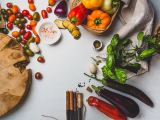 Italian food ingredients background with vegetables, salt, spices and herbs, cheese, olive oil, basil, bell peppers, eggplant and tomatoes, copy space