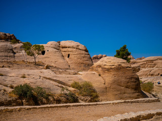 Interesting rock formations of ancient temples built into sandstone walls in the historic city of Petra, Jordan