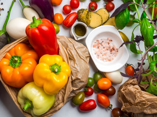 Italian food ingredients background with vegetables, salt, spices and herbs, cheese, olive oil, basil, bell peppers, eggplant and tomatoes, copy space