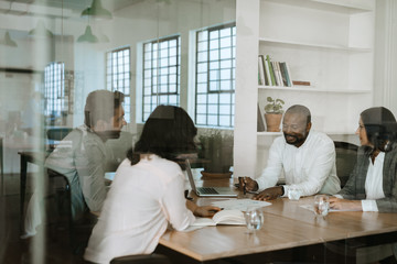 Fototapeta na wymiar Diverse businesspeople discussing work together during an office meeting
