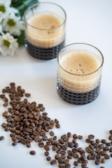 Cups of black coffee. Coffee in glass, Coffee cups, beans and flowers on white  table 