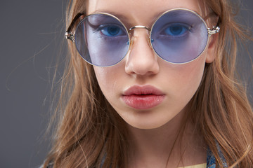 Fototapeta premium Charming teenage girl wearing blue round glasses