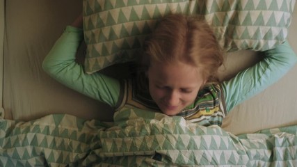 little child blonde girl waking up with the alarm clock