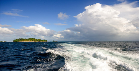 Wide angle shot on the open sea with blue and tourquoise oceans's surface with waves and blue sky with cloudsduring a boat trip around the wonderful island Samana, Dominican Republic in the Caribbean.