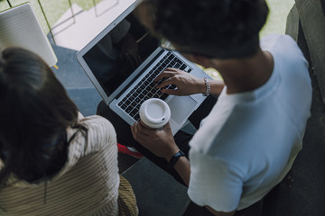 Man typing on keyboard of his laptop