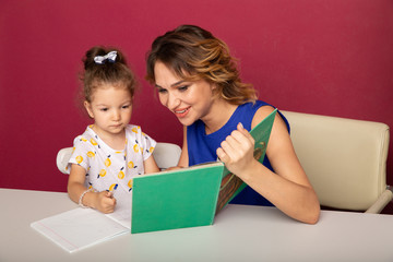 Pretty family concept. Mom and daughter sitting together and studying at home