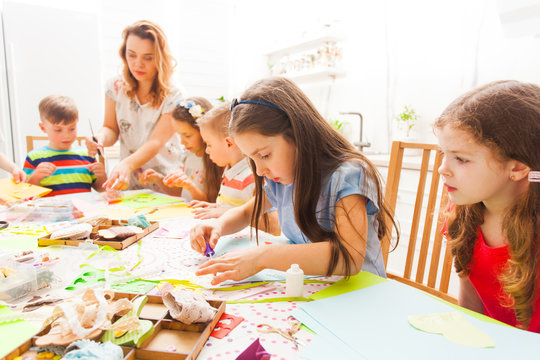 Children do applique work with the help of a teacher