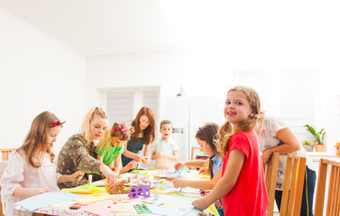 Children make greeting cards together with their mothers
