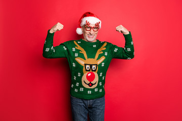 Merry december x-mas newyear. Photo of white grey-haired handsome funky feeling young guy demonstrating his huge triceps on hands wear green jeans retro jumper isolated bright color background