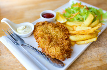 Batter fried dolly fish wrapped bread steak with salad on dish.