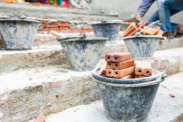 Worker labor, Mixer operator building staircase with concrete cement and brick at construction site.